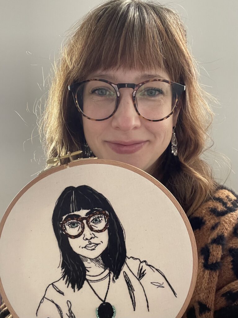 Emily Levenson of Made With Lev holding an embroidered self portrait in black and white